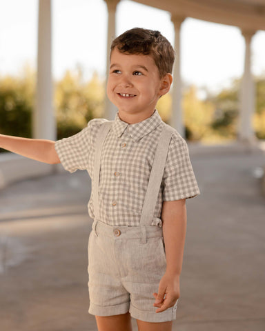 Boy in suspenders and gingham top