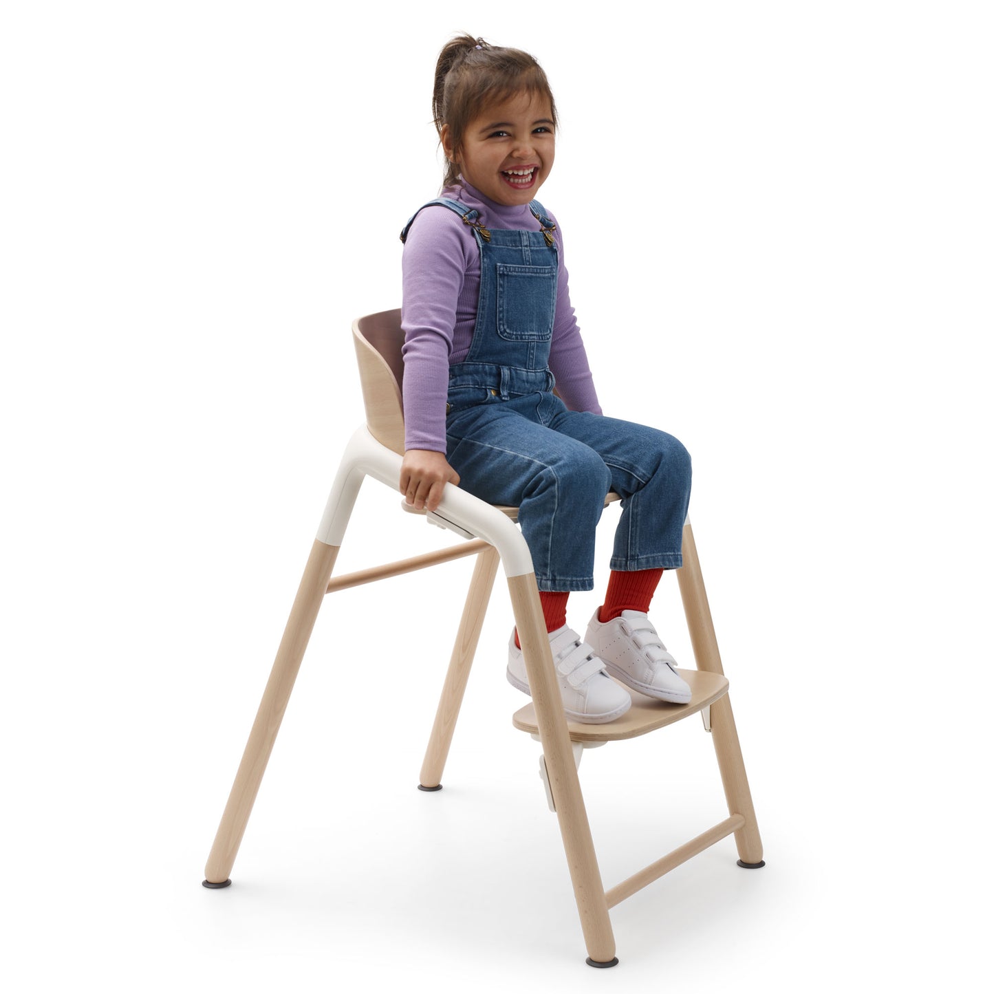 Child sits in Bugaboo Giraffe High Chair Complete - Natural Wood/White